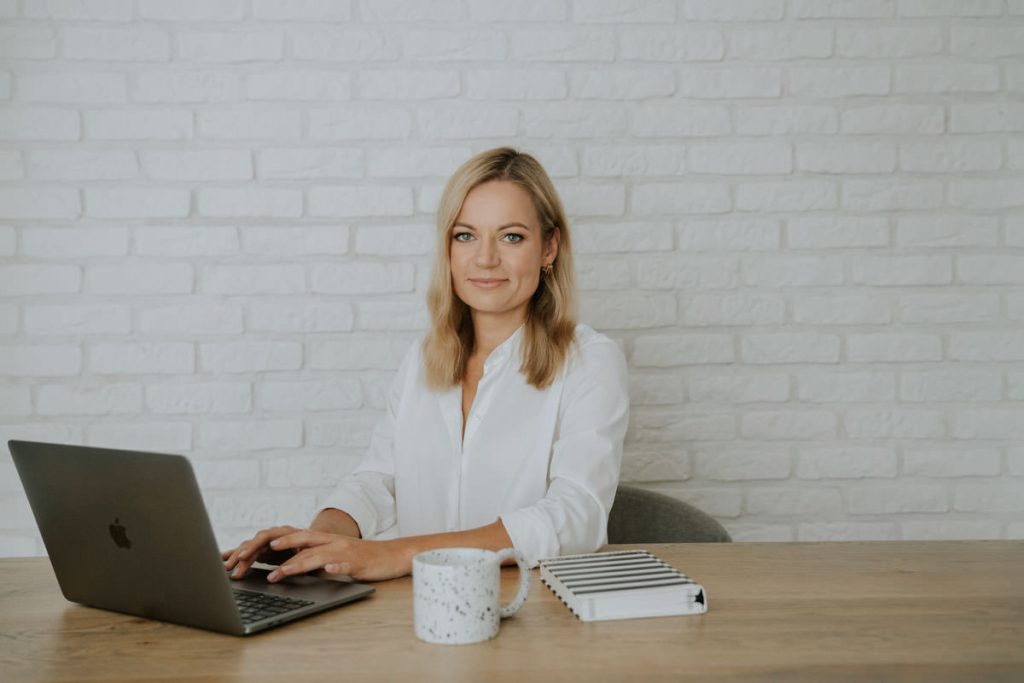 Marta przy komputerze z kubkiem i notesem